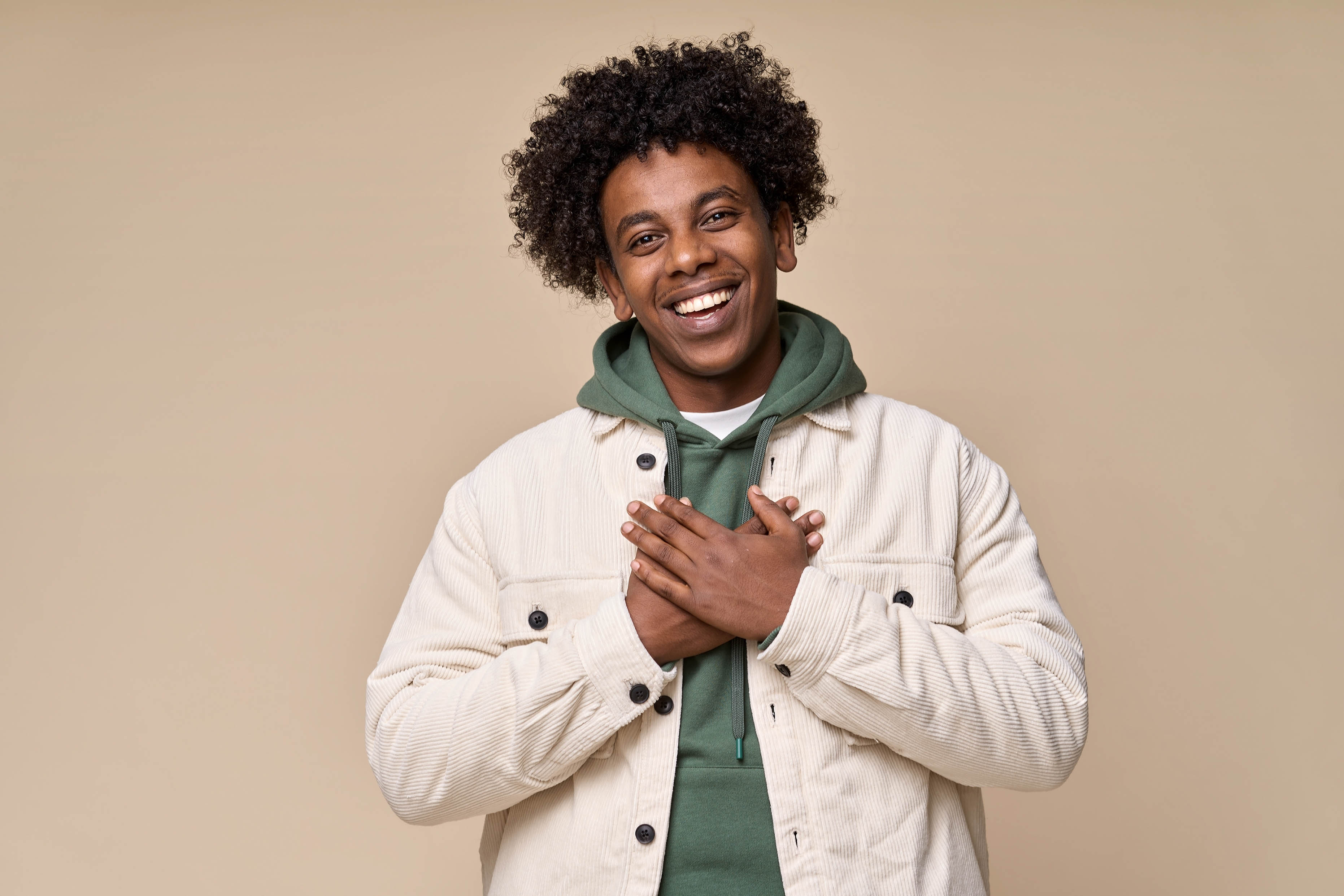 Young African American man with his hands on his heart and smiling Young African American man with his hands on his heart and smiling